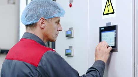 Factory-worker-working-with-touch-screen-of-industrial-computer-equipment