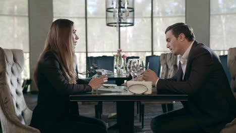 Business-couple-meeting-in-restaurant.-Adult-man-and-woman-talking-at-cafe-table