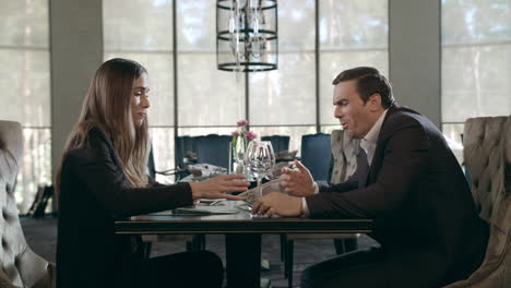 Business-couple-talking-at-restaurant.-Man-and-woman-laughing-at-cafe-meeting