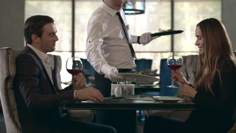 Glückliches-Paar,-Das-Im-Restaurant-Mit-Einem-Glas-Rotwein-Anstößt