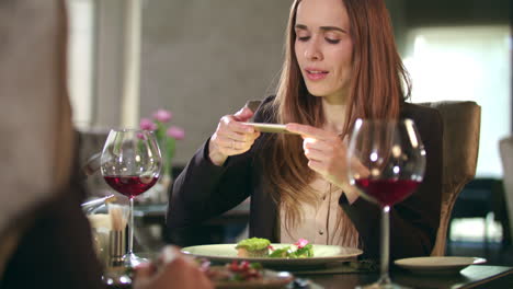 Businesswoman-taking-food-photo-on-smartphone-at-restaurant