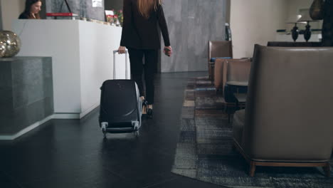 Business-woman-with-travel-suitcase-arriving-in-hotel-at-vacation