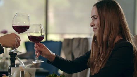 Attractive-woman-clinking-wine-glass-in-restaurant.-Woman-drinking-red-wine