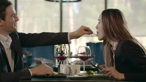 Handsome-man-feeding-woman-at-romantic-dinner.-Couple-dining-at-romantic-date