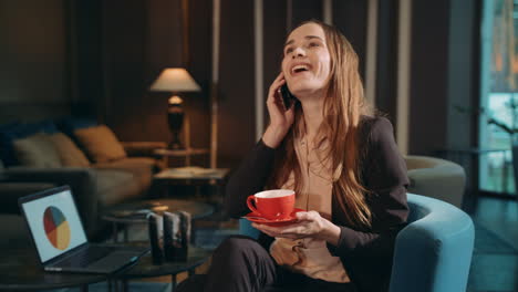 Smiing-woman-calling-mobile-in-hotel-lounge.-Business-woman-talking-smartphone