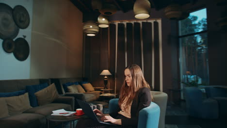 Focused-woman-working-laptop-in-hotel.-Business-woman-using-laptop-in-office
