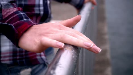 Woman-hands-on-steel-fence.-Elegant-woman-manicured-hands