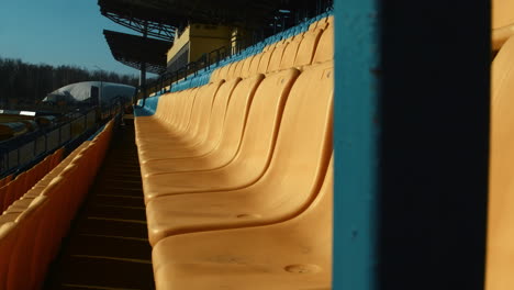 Rows-of-numbered-plastic-chairs-in-open-football-stadium