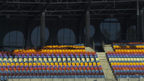 Football-stadium-with-nobody-from-tribunes.-Empty-different-colors-seats