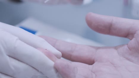 Doctor-hand-take-blood-test-from-patient-finger-at-lab.-Close-up-of-blood-test