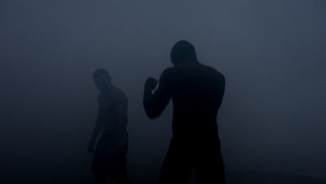 Boxers-silhouettes-starting-to-fight-at-dark-ring.-Boxing-fight.-Sparring-boxers