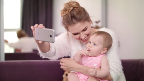 Beautiful-woman-making-selfie-with-baby.-Mother-with-child-taking-mobile-photo