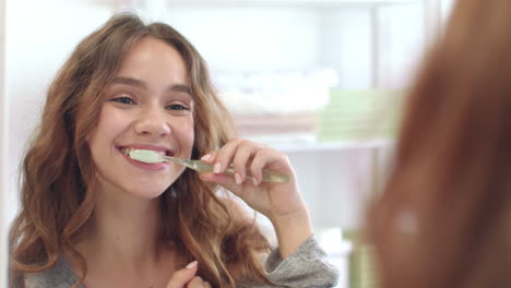 Mujer-Sonriente-Cepillando-Los-Dientes-Espejo-Frontal-En-El-Baño.-Higiene-Bucal-Y-Dental