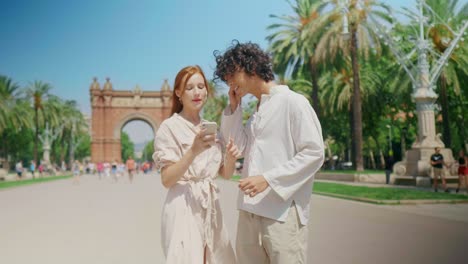 Closeup-tourist-couple-searching-direction-with-phone.-Happy-couple-checking-way