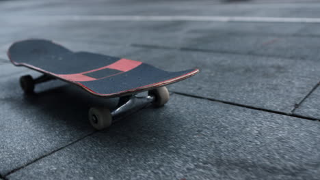 Closeup-skateboard-rolling-on-city-street.-Black-and-red-longboard-outdoor.