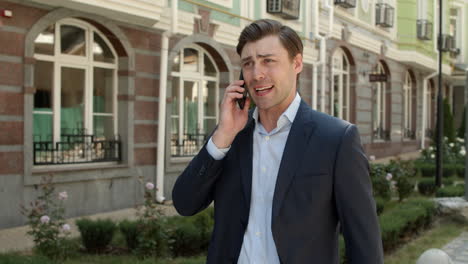 Closeup-man-talking-phone-outdoor.-Man-discussing-business-issue-at-street