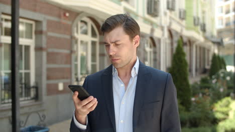 Closeup-man-using-modern-phone-at-street.-Businessman-typing-number-outdoor