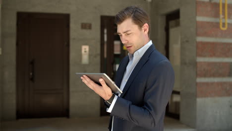 Closeup-businessman-holding-tablet-at-street.-Man-using-tablet-for-work-outdoor