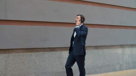 Side-view-man-talking-phone-with-partner-outdoor.-Business-man-having-phone-talk
