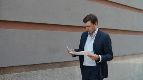Business-man-walking-with-papers.-Man-holding-documents-at-street