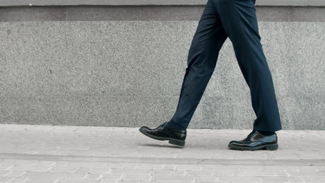 Imagen-Recortada-Hombre-Caminando-Con-Zapatos-Negros.-Primer-Plano-De-Los-Pies-Masculinos-Que-Van-Cerca-Del-Edificio