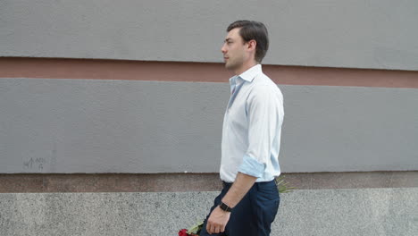 Closeup-businessman-going-on-date-with-roses.-Man-walking-with-beautiful-flowers