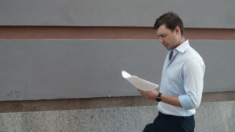Closeup-businessman-reading-papers-outdoor.-Man-throwing-documents-at-street
