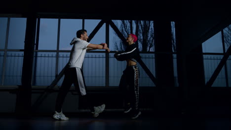 Sporty-couple-dancing-hip-hop-indoors.-Funky-dancers-exercising-moves-in-studio.