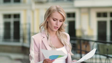 Business-woman-reading-documents-at-street.-Businesswoman-working-with-papers