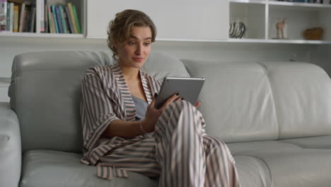 Woman-surfing-internet-online-at-home-interior.-Surprised-girl-use-pad-computer