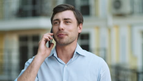 Close-up-businessman-talking-phone.-Man-talking-phone-in-shirt-outdoors