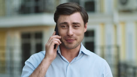 Portrait-man-having-phone-talk-outdoor.-Man-talking-on-phone-in-shirt-outdoor