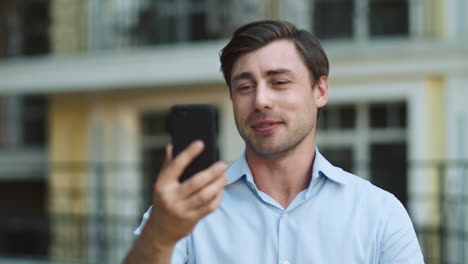 Closeup-businessman-using-phone-for-video-call.-Man-having-video-chat-at-street