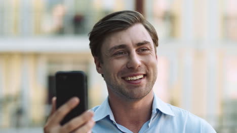 Portrait-man-using-phone-for-video-chat.-Businessman-making-video-call-outside
