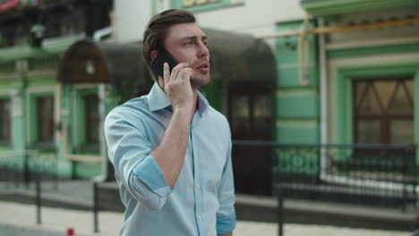 Business-man-walking-with-mobile-phone-at-street.-Smiling-businessman-call-phone