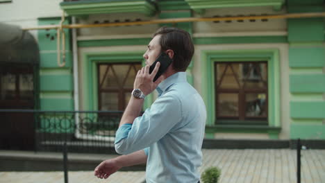 Serious-business-man-talking-phone-outdoors.-Businessman-walking-with-smartphone