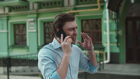 Businessman-having-talk-on-mobile-phone.-Man-talking-phone-in-shirt-at-street