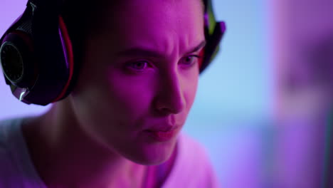 Focused-cyber-girl-playing-computer-game-in-headset-closeup.-Esport-gaming-night