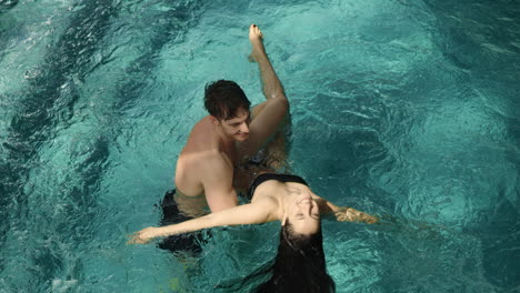 Happy-couple-having-fun-in-pool.-Happy-man-looking-beautiful-woman-in-spa.