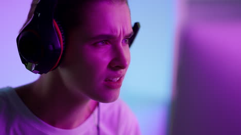 Esport-player-looking-screen-in-neon-lights-closeup.-Stressed-girl-in-cyberspace