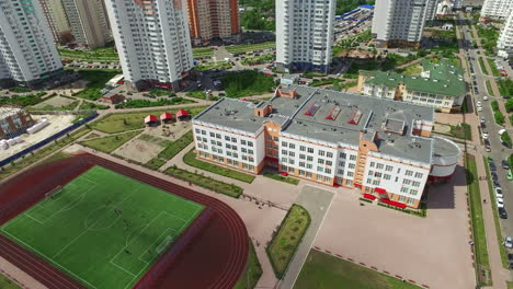 Sports-stadium-in-schoolyard-on-high-rise-buildings.-Aerial-view-football-field