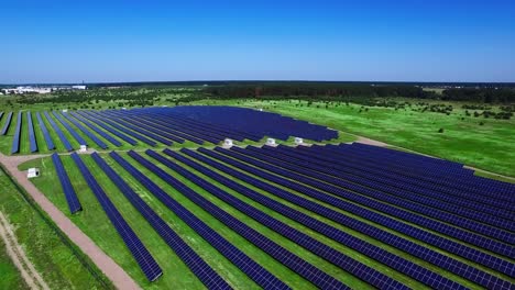 Photovoltaic-solar-panels-on-green-field-at-sunny-day.-Aerial-landscape