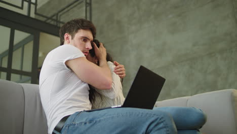 Portrait-of-scared-couple-looking-computer-screen-at-sofa-in-slow-motion.