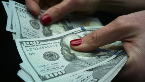Woman-checking-amount-of-cash-money.-Hands-holding-one-hundred-dollar-bills