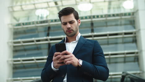 Portrait-businessman-using-phone.-Man-looking-away-in-stylish-suit-at-street