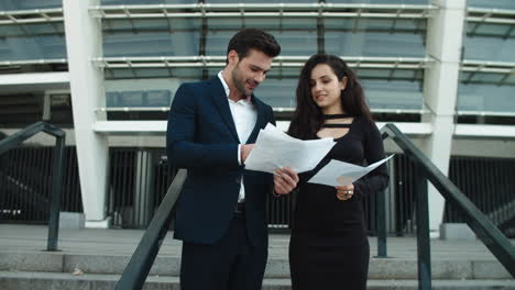 Closeup-couple-standing-with-papers.-Couple-analyzing-documents-outside