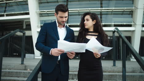 Closeup-couple-reading-documents-near-stadium.-Couple-standing-together-outside