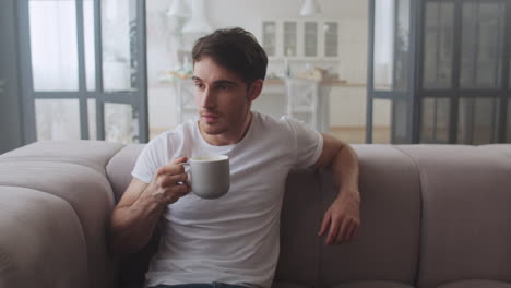 Serious-freelancer-relaxing-with-cup-of-tea-at-home.-Handsome-man-drinking-tea.