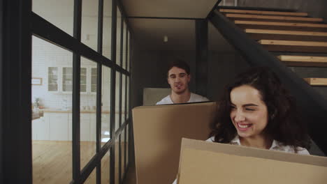 Happy-couple-with-boxes-moving-to-new-apartment.-Couple-hugging-at-kitchen.