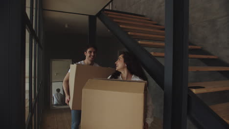 Closeup-happy-couple-with-boxes-moving-to-luxury-house-together.